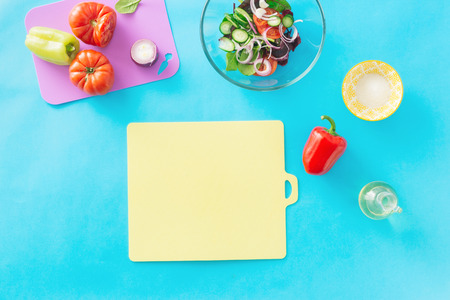 Empty kitchen cutting board with set ingredients for cooking summer salad on blue background, top view. Healthy food concept. Diet foodの写真素材