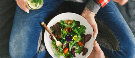 Close up woman eating salad, top view. Healthy food conceptの写真素材