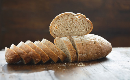 Chopped fresh bread on wooden table close up