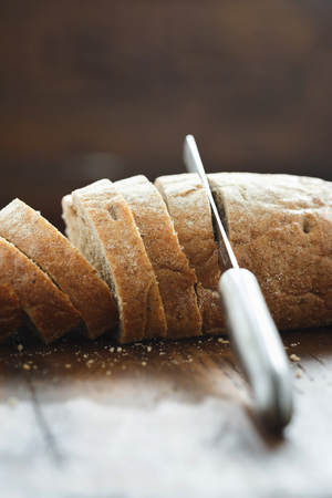 Chopped fresh bread on wooden table close-upの写真素材
