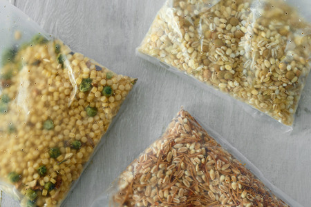 Set of various healthy raw quick cook cereal on wooden table, top view. Barley couscous, pearl...