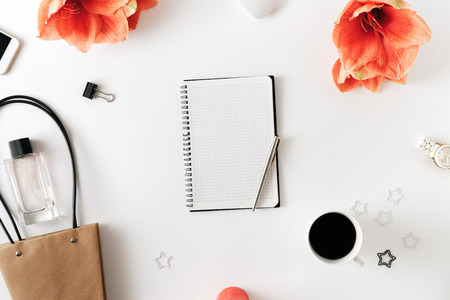 Flat lay, top view office table desk. Feminine desk workspace with flower amaryllis, notepad, pen,...