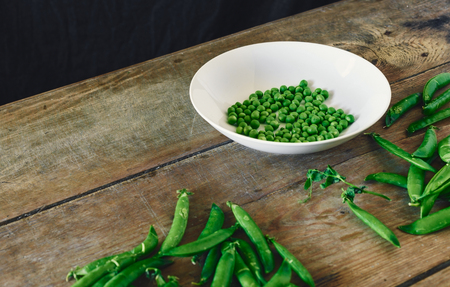 Bowl fresh green peas on wooden table, rustic styleの写真素材
