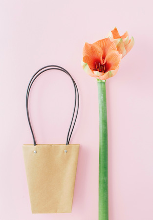 Minimal layout made of amaryllis flower and paper bag on pink pastel background. Flat lay. Top view. Creative shopping backgroundの写真素材