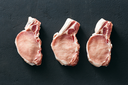 Set piece of fresh pork meat on dark stone background, top viewの写真素材