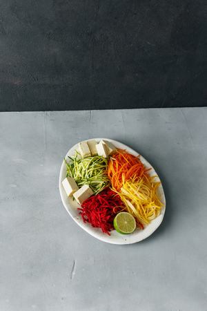 Healthy clean spiralized vegetables with tofu cheese on gray concrete tableの写真素材