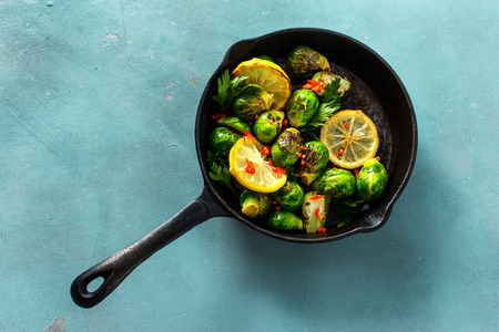 Fried broccoli served in a cast-iron frying pan on blue stone background, top view Healthy Vegetarian Foodの写真素材