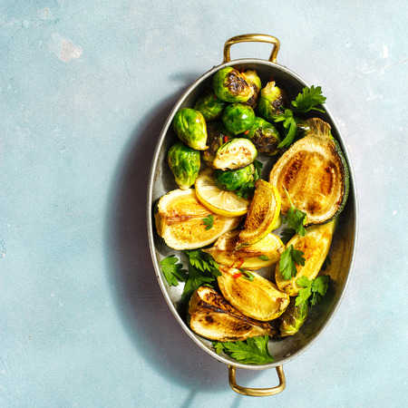 Flat lay Fried brussels sprouts with zucchini served in frying pan on blue stone background Healthy Vegetarian Food top viewの写真素材