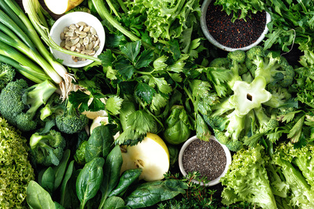 Healthy food ingredients background. Vegetables, fruit, superfood and herbs top view. Celery, parsley, onion, Brussels sprouts, lettuce leaves, lime, baby spinach, broccoli, quinoa, green apple, chia seeds and pumpkin seedsの写真素材