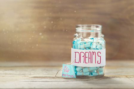 Dream house concept. Dreams jar. Full glass jar of cherished wishesの写真素材