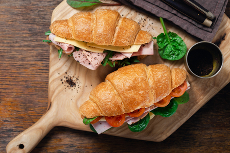 Breakfast croissant sandwiches served on wooden boardの写真素材