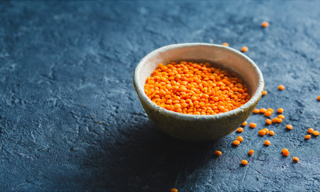 Red lentils in a bowl close up with copy spaceの写真素材