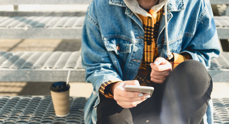 Young woman texting sitting on the city stepsの写真素材