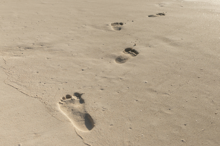 Summer vacation background. Footprints on the ocean sandの写真素材