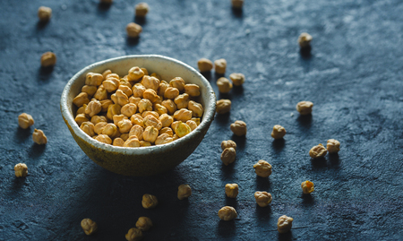 Bowl with chickpea close up on dark stone background with copy spaceの写真素材