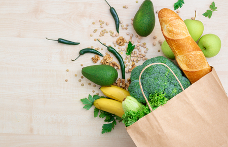 Bag food concept. Groceries shopping paper bag with healthy food on a wooden  top viewの写真素材