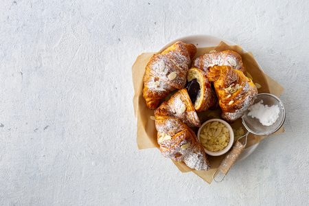 Vegan croissants with almond flakes and icing sugar top view copy spaceの写真素材