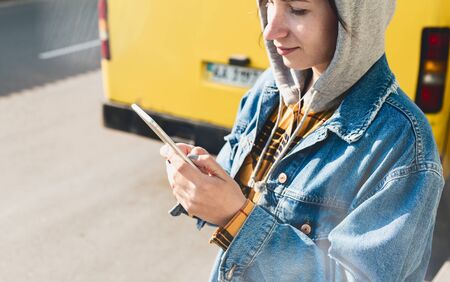 Happy young woman using social media on their smartphones walking down a city streetの写真素材