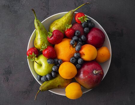 Fruits plate on a dark background top viewの写真素材