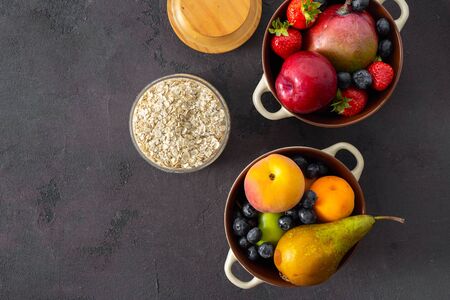 Raw cereals with fruit on a dark background top view