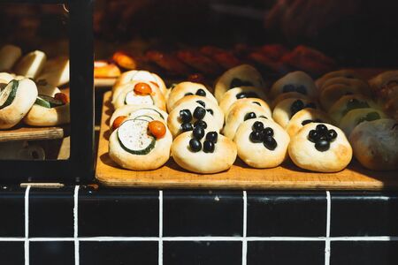 Various buns with different fillings on the bakery shop windowの写真素材