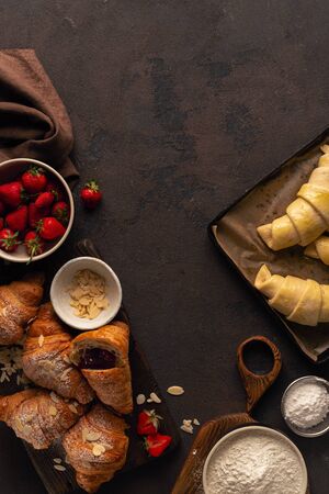 Croissant with jam strawberry on a stone background top viewの写真素材