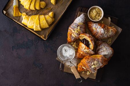 Breakfast croissant with almond flakes and icing sugar top viewの写真素材