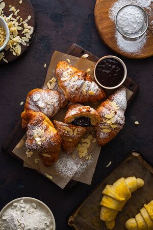 Fresh croissants with chocolate on a dark stone background top viewの写真素材