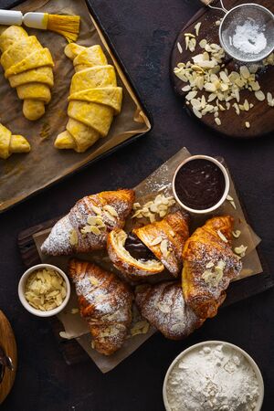 Freshly baked croissant with almond flakes and icing sugar top viewの写真素材