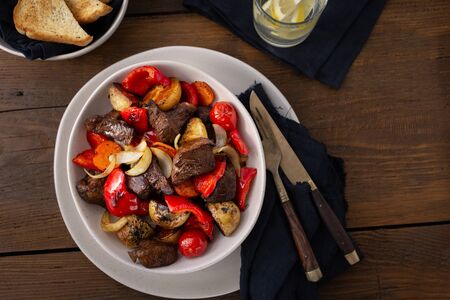 Plate fried beef meat, new potatoes and vegetables top viewの写真素材