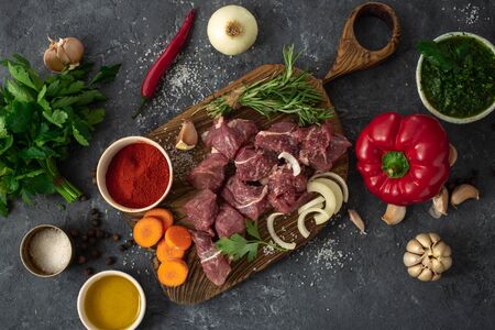 Cuts beef with vegetable. kitchen table with ingredients cooking meat and veggiesの写真素材