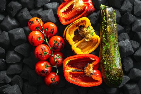 Cooked vegetables grilled over a charcoal top viewの写真素材