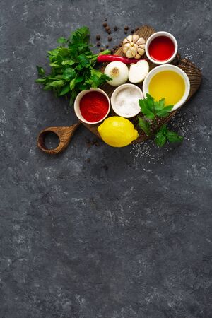 Restaurant menu concept. Ingredients for cooking Argentinian green Chimichurri or Chimmichurri salsa or sauce on dark stone background top viewの写真素材