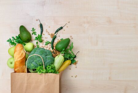Groceries shopping bag with healthy food on a wooden background top viewの写真素材
