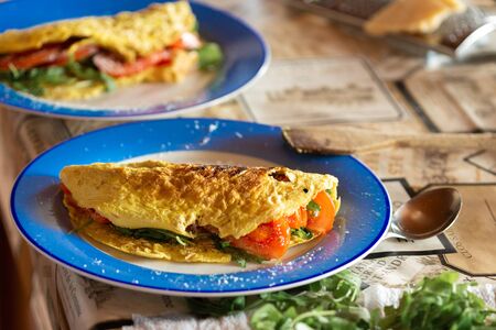 Healthy breakfast. Omelet with tomatoes and arugula on a plate in the home kitchenの写真素材