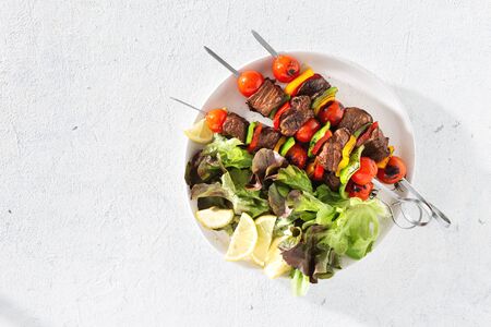 Plate with beef grilled meat kebab on a white table top viewの写真素材
