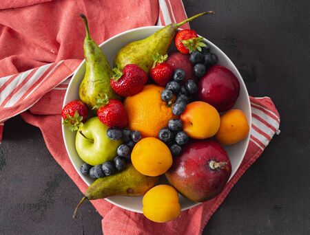 Fruits plate on a dark background top viewの写真素材