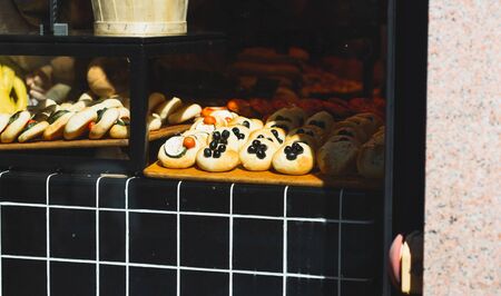 Various buns with different fillings on the bakery shop windowの写真素材