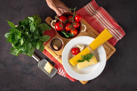 Raw pasta with ingredients for cooking Italian spaghetti on dark backgroundの写真素材