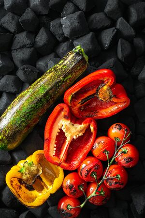 Cooked vegetables grilled over a charcoal top viewの写真素材