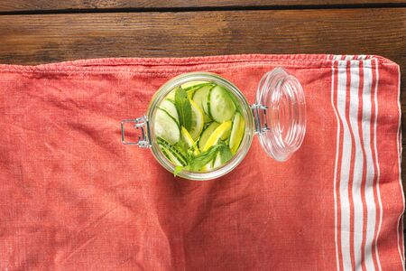 Detox drink cucumber water in the glass on wooden table top viewの写真素材