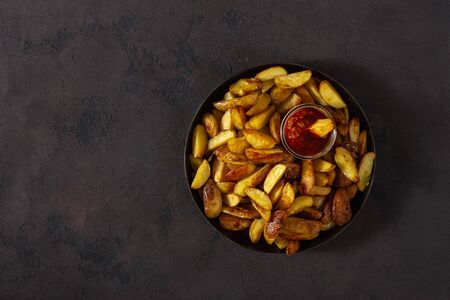 Fried potatoes with  brava sauce on a dark background with copy space top viewの写真素材