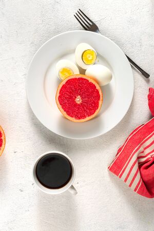 Boiled egg diet concept. Eggs with grapefruit and cup of black coffeeの写真素材