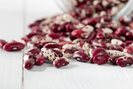 Scattered red beans on a wooden table close upの写真素材