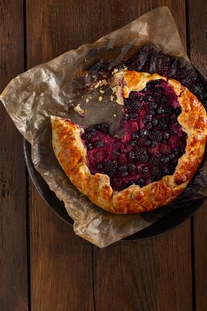Fruit pie with strawberry, blueberry, blackberry and raspberry on a woodenの写真素材