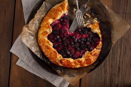 Fruit pie with strawberry, blueberry, blackberry and raspberry on a woodenの写真素材