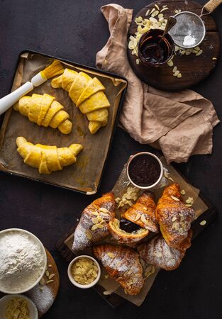Fresh croissants with almond flakes and icing sugar top viewの写真素材