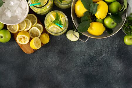 Summer drink concept. Sugar free fresh lemonade with apples and lemon on a dark background top viewの写真素材