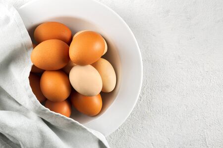 Brown eggs in plate on a white background with copy space top viewの写真素材