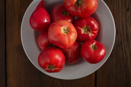 Fresh red tomatoes on a wooden background top viewの写真素材